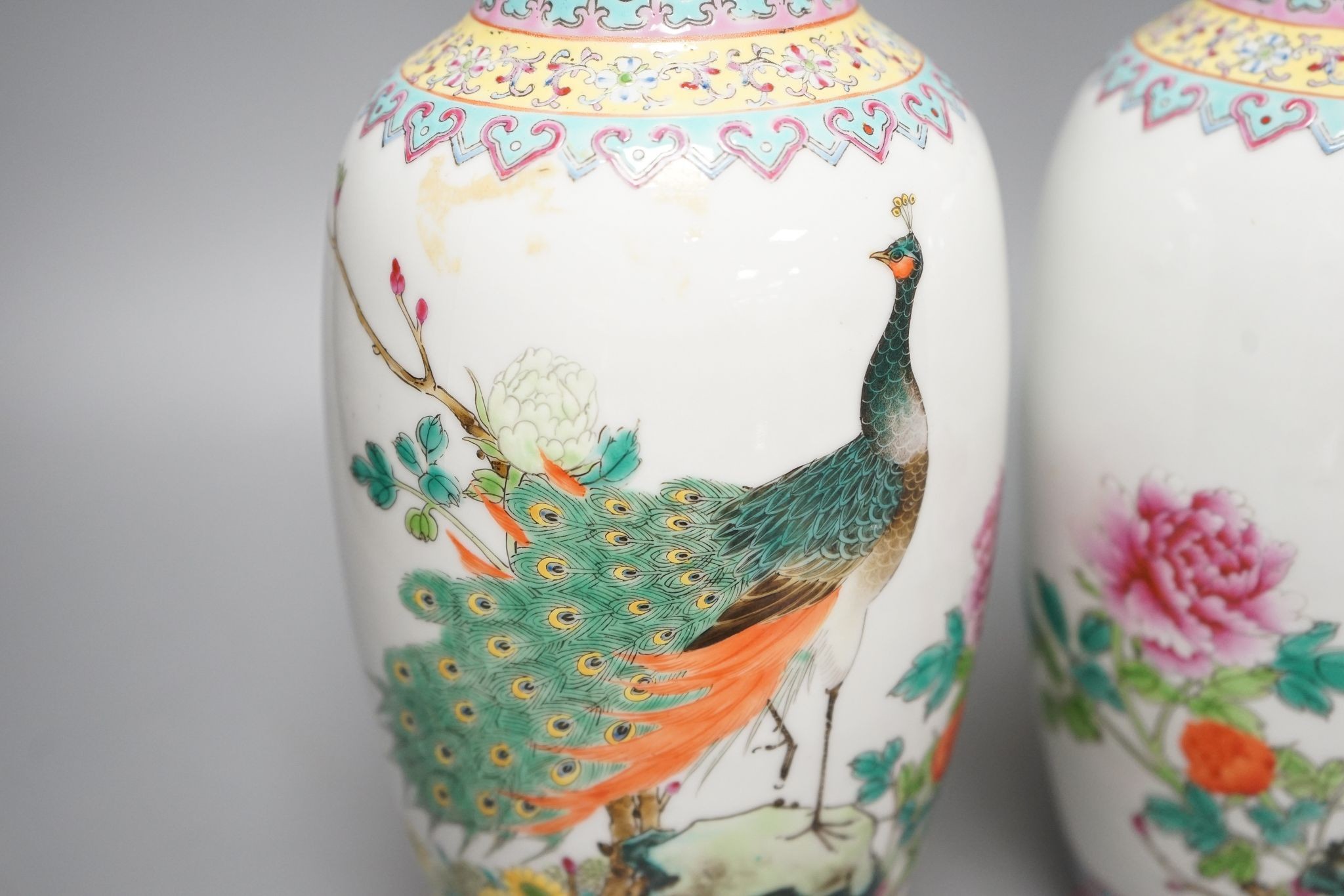 A pair of Chinese famille rose vases decorated with peacocks, 31cm